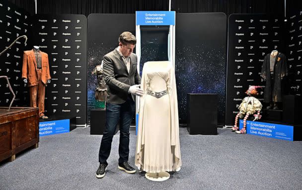 PHOTO: Brandon ALinger, Chief Operating Officer at Propstore, wears white gloves to handle the Princess Leia dress worn by actress Carrie Fisher in the 1977 film 'Star Wars' for display on May 16, 2023 at Propstore in Valencia, Calif. (Frederic J. Brown/AFP via Getty Images)