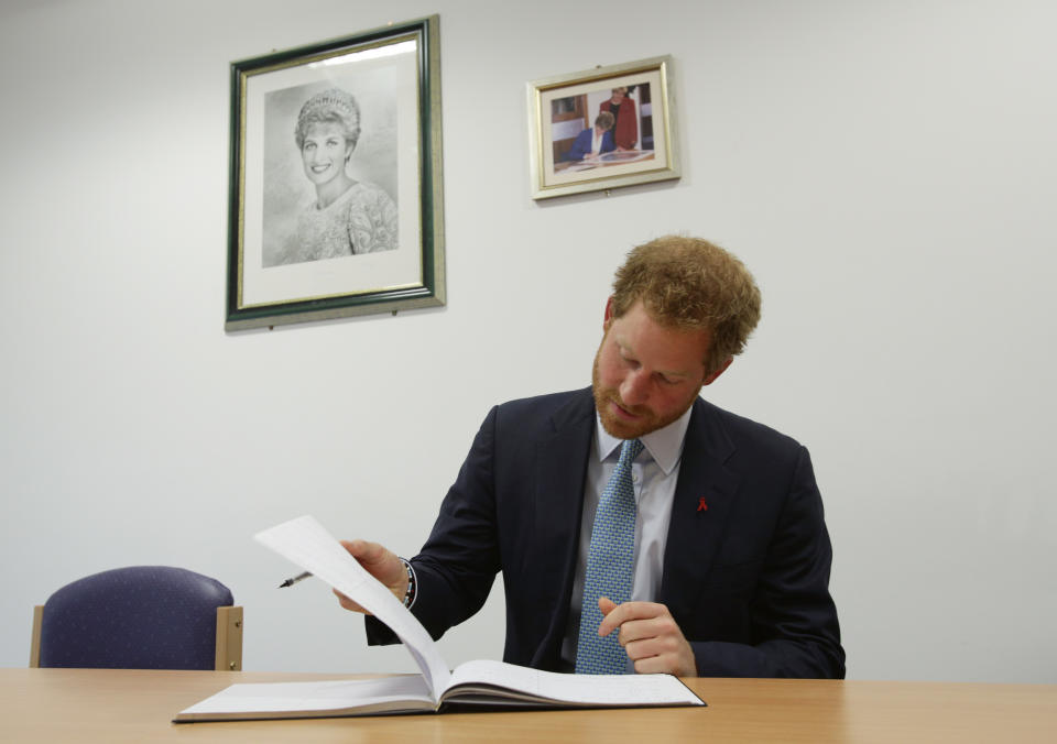 LONDON, ENGLAND - DECEMBER 14: Prince Harry signs the visitors book during a visit to Mildmay hospital, a dedicated HIV hospital, to mark the opening of the new purpose built facility at Mildmay Hospital on December 14, 2015 in London, England.  (Photo by Yui Mok-WPA Pool/Getty Images)