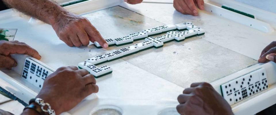 Close up view of individuals playing the domino game in the historic Domino Park in popular Little Havana.