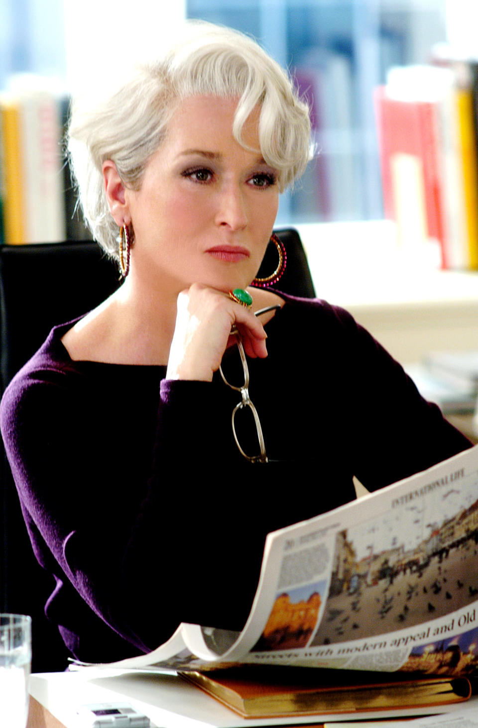 Meryl Streep looking pensive with a newspaper in her hand