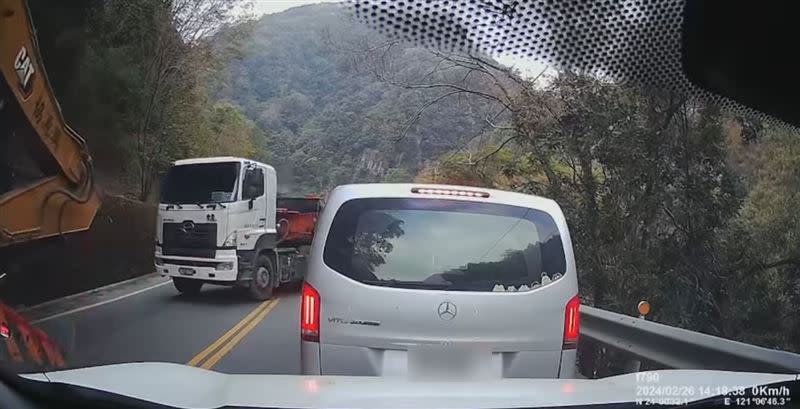 砂石車跨雙黃線想超越前方載挖土機地拖板車，幸好商旅車及時煞車，隨後砂石車若無其事切回原車道繼續開。(圖／翻攝自爆料公社二社臉書)