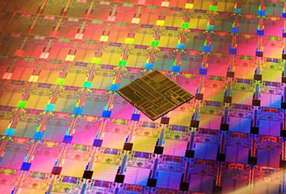 A wafer of Intel chips with another chip on top of it.