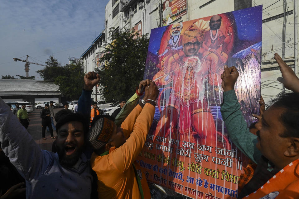 Supporters in celebration pour milk on a billboard depicting Chief Minister Shivraj Singh Chouhan as Hindu monkey god Hanuman following Bharatiya Janata Party's lead in the Madhya Pradesh state elections in Bhopal, India, Sunday, Dec.3 2023. (AP Photo/Abdul Mujeeb Faruqui)