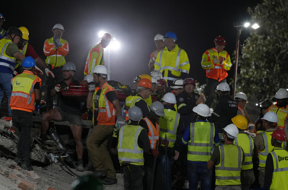 A rescue team carries a person from the site of a building collapse in George, South Africa, Tuesday night, May 7, 2024. Rescue operations continue Wednesday for dozens of construction workers missing. (AP Photo/Nardus Engelbrecht)