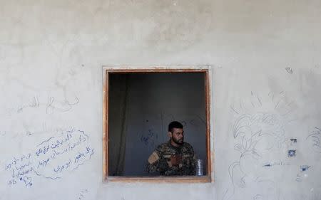 A Kurdish fighter from the People's Protection Units (YPG) gestures in a house in Raqqa, Syria July 2, 2017. REUTERS/Goran Tomasevic