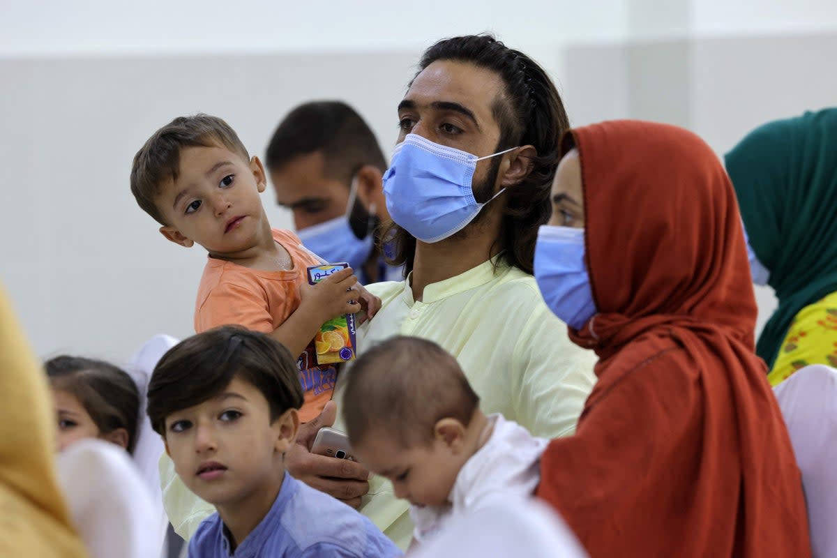 Refugees who fled Afghanistan after the takeover of their country by the Taliban, gather at the International Humanitarian City (IHC) in Abu Dhabi on 28 August 2021 (AFP via Getty Images)