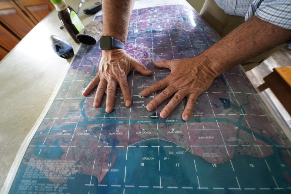 CEO and president Harold Osborn, great-great-grandson of the McIlhenny Co.'s founder, looks at a map of the company's land and surrounding area, inside an old trapper's camp that has been restored and repurposed by the company, on Avery Island, La., where Tabasco brand pepper sauce is made, Tuesday, April 27, 2021. (AP Photo/Gerald Herbert)