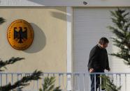 A bullet hole is seen on the wall as German Ambassador in Greece, Wolfgang Dold, stands at his residence's balcony following an attack by unknown gunmen early December 30, 2013 in an Athens suburb. Unidentified assailants opened fire on the German ambassador's residence in Athens with a Kalashnikov assault rifle early on Monday in an attack seen as an attempt to sour relations between debt-laden Greece and its biggest creditor nation. REUTERS/Yannis Behrakis (GREECE - Tags: POLITICS CRIME LAW)