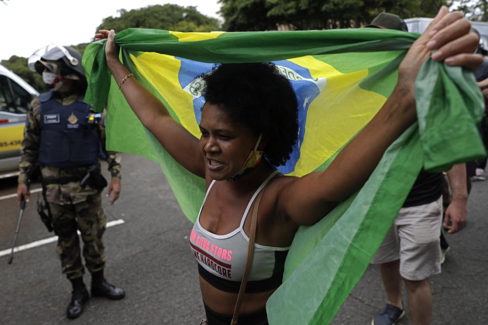 A demonstrator with a Brazilian flag protests the lockdown on the first day it goes into effect to curb the spread of COVID-19 in Brasilia, Brazil, Monday, March. 1, 2021. It’s the second lockdown since the start of the pandemic one year ago. (AP Photo/Eraldo Peres)