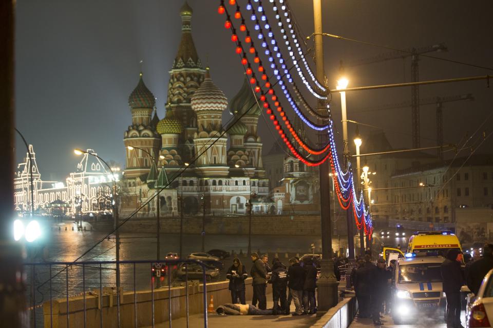 FILE - Police investigate the body of Boris Nemtsov, an opposition leader and a former deputy prime minister, with the St. Basil's Cathedral and Red Square in the background in Moscow, Russia on Feb. 28, 2015. Nemtsov, a top figure of Russia's beleaguered political opposition, is gunned down on a bridge next to the Kremlin. Nemtsov was working on a report about Russian soldiers in eastern Ukraine. (AP Foto/Pavel Golovkin, File)