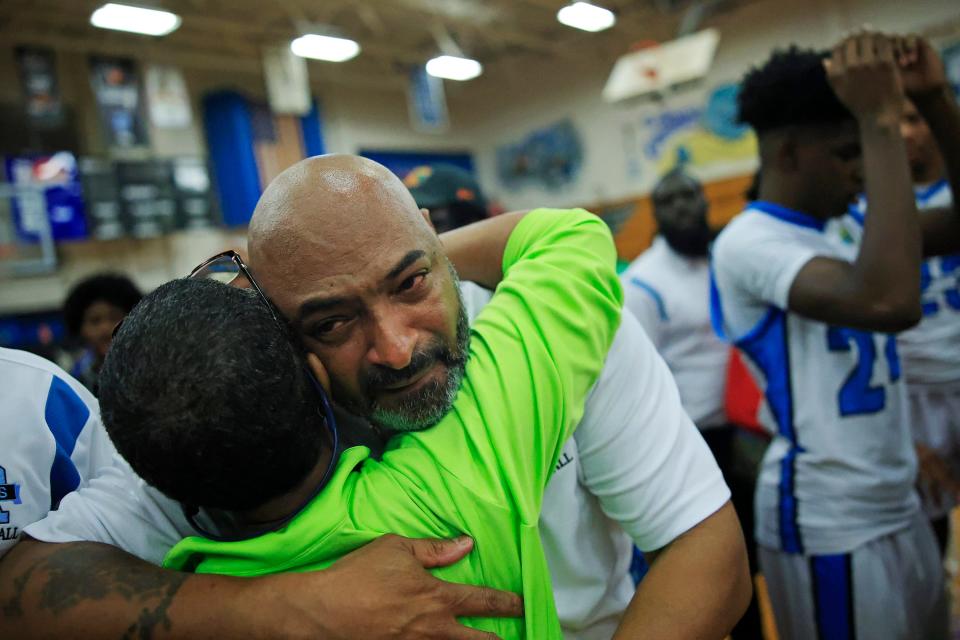 Ribault's head coach Charles Showers reacts to the win while hugging friend Mae Haynes after the game of the 2022-2023 Gateway Conference boys high school basketball tournament final Friday, Jan. 27, 2023 at Jean Ribault High School in Jacksonville, Fla. The Ribault Trojans defeated the Andrew Jackson Tigers 60-55 in overtime. 