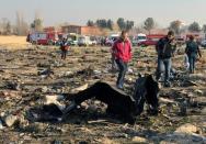 Iranian recovery teams inspect the wreckage of the Ukrainian airliner which crashed shortly after takeoff from Tehran with the loss of all 176 people on board