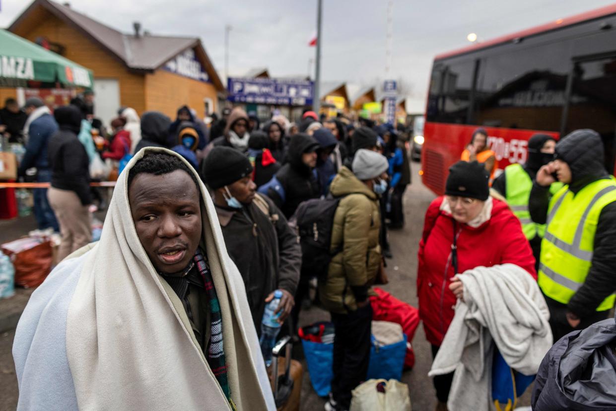 International refugees, including those from Africa, the Middle East and India, wait at a border crossing in eastern Poland