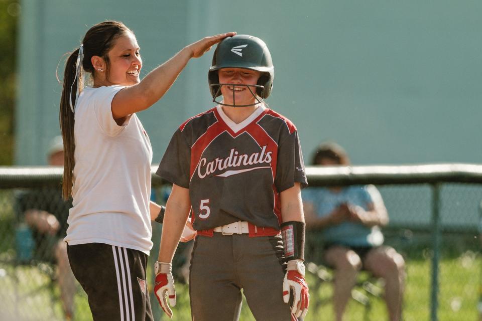 Sandy Valley softball's head coach, Cortney Geiger, pats Peyton Nicholson on the head for rounding out third base during a game against Garway, Monday, April 29 at Sandy Valley Local Schools.