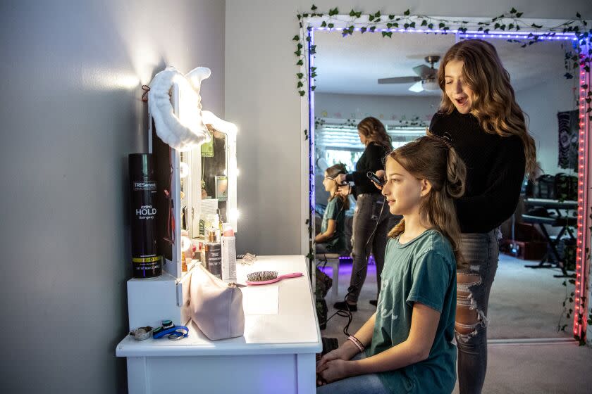 STUDIO CITY, CA - SEPTEMBER 30: Claire Rock Smith, 13, curls her sisters hair, Reese Rock Smith, 10, at their home on Friday, Sept. 30, 2022 in Studio City, CA. (Mariah Tauger / Los Angeles Times)