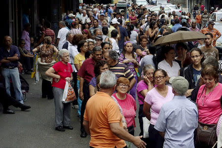 People queue to try to buy basic food items outside a supermarket in Caracas March 16, 2016. REUTERS/Carlos Garcia Rawlins/File Photo