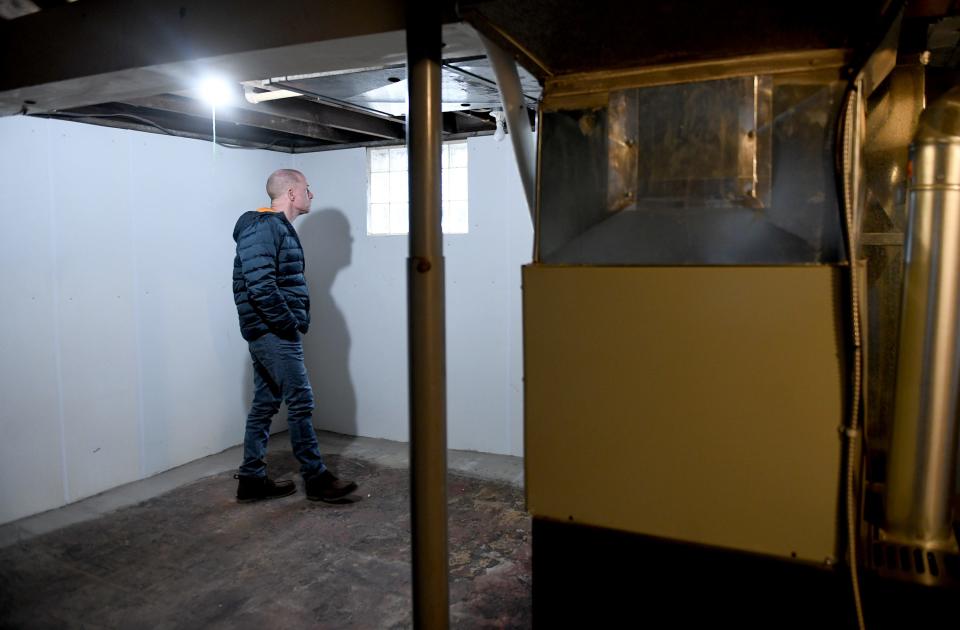 John Hunt looks around the basement last week of his new North Canton home. Real estate experts say the hot housing market is expected to cool off this year.