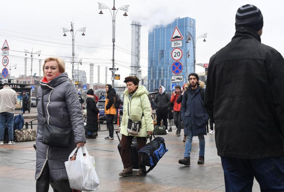 Kyiv residents by a railway station with suitcases on the first day of the Russian invasion (AFP/Getty)