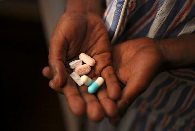 FILE PHOTO: Nine-year-old Tumelo shows off antiretroviral (ARV) pills before taking his medication at Nkosi's Haven, south of Johannesburg