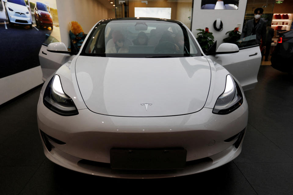 A látogatók egy Tesla Model 3-at ellenőriznek az amerikai elektromos járműveket (EV) gyártó bemutatótermében Pekingben, Kínában, 2023. február 4-én. REUTERS/Florence Lo
