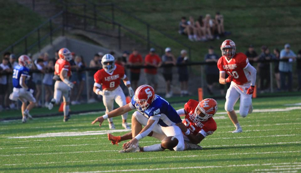 Heath's Daylen McIntyre forces a fumble while sacking Sheridan's Caden Sheridan during Licking County's 40-26 loss to Muskingum Valley.