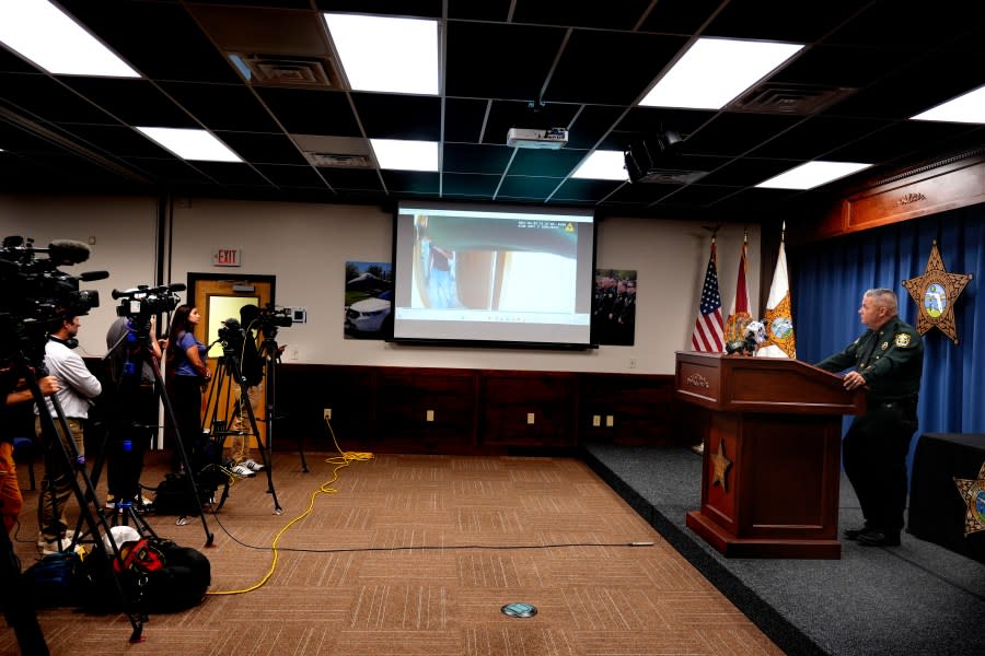 CORRECTS SERVICE BRANCH TO U.S. AIR FORCE INSTEAD OF U.S. NAVY – Okaloosa County Sheriff Eric Aden holds a news conference where he shared deputy body cam footage, displayed on screen at center, of the May 3, 2024 shooting of Roger Fortson, a U.S. Air Force senior airman, Thursday, May 9, 2024, in Fort Walton Beach, Fla. Fortson was shot in his apartment after a response to a complaint. (AP Photo/Gerald Herbert)