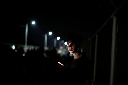 A Honduran migrant, part of a caravan trying to reach the U.S., is pictured on the bridge that connects Mexico and Guatemala in Ciudad Hidalgo, Mexico, October 19, 2018. REUTERS/Ueslei Marcelino