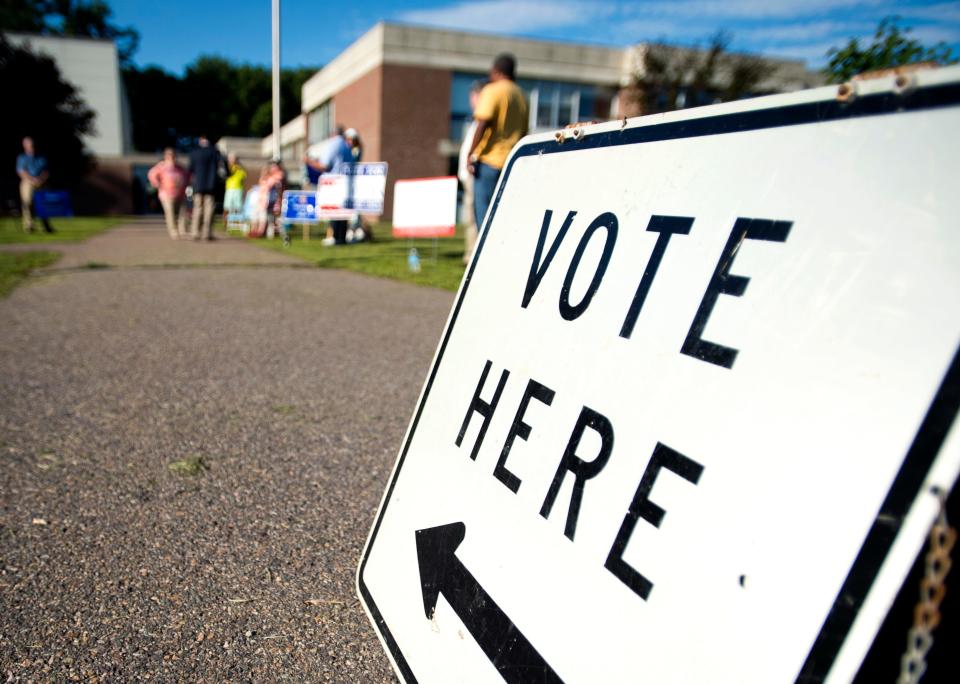 Candidates and campaigners wait for voters outside of Essex Middle School during the August primary election in 2014.