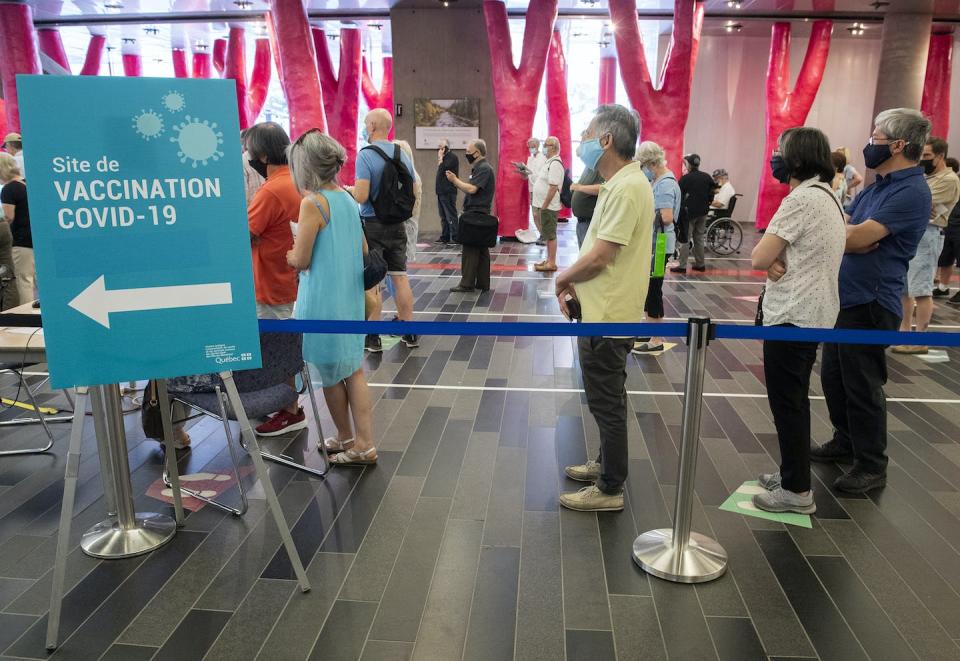 People waiting in line for COVID-19 vaccine booster shots in June 2021. THE CANADIAN PRESS/Graham Hughes