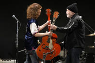 Canadian rock legend Randy Bachman, right, receives his stolen Gretsch guitar during the Lost and Found Guitar Exchange Ceremony Friday, July 1, 2022, at Canadian Embassy in Tokyo. Bachman’s long-held dream came true Friday when he was reunited in Tokyo with a beloved guitar nearly a half-century after it was stolen from a Toronto hotel. Bachman, 78, a former member of The Guess Who, received the guitar from a Japanese musician who had bought it at a Tokyo store in 2014 without knowing its history. (AP Photo/Eugene Hoshiko)