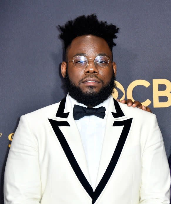 wearing a crisp, retro-inspired suit and bowtie, Stephen Glover poses on the red carpet