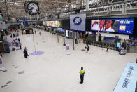 FILE - Few passengers walk at Waterloo East station as train services continue to be disrupted following the nationwide strike by members of the Rail, Maritime and Transport union along with London Underground workers in a bitter dispute over pay, jobs and conditions, in London, on June 23, 2022. As food costs and fuel bills soar, inflation is plundering people’s wallets, sparking a wave of protests and workers’ strikes around the world. (Victoria Jones/PA via AP)