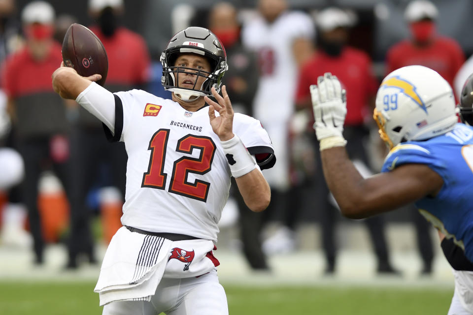 Tampa Bay Buccaneers quarterback Tom Brady (12) throws a pass as he is pressured by Los Angeles Chargers defensive tackle Jerry Tillery (99) during the first half of an NFL football game Sunday, Oct. 4, 2020, in Tampa, Fla. (AP Photo/Jason Behnken)