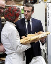 French President Emmanuel Macron speaks with a bread maker during a visit to the International Agriculture Fair (Salon de l'Agriculture) at the Porte de Versailles exhibition center in Paris, Saturday, Feb. 22, 2020. (Benoit Tessier/Pool via AP)