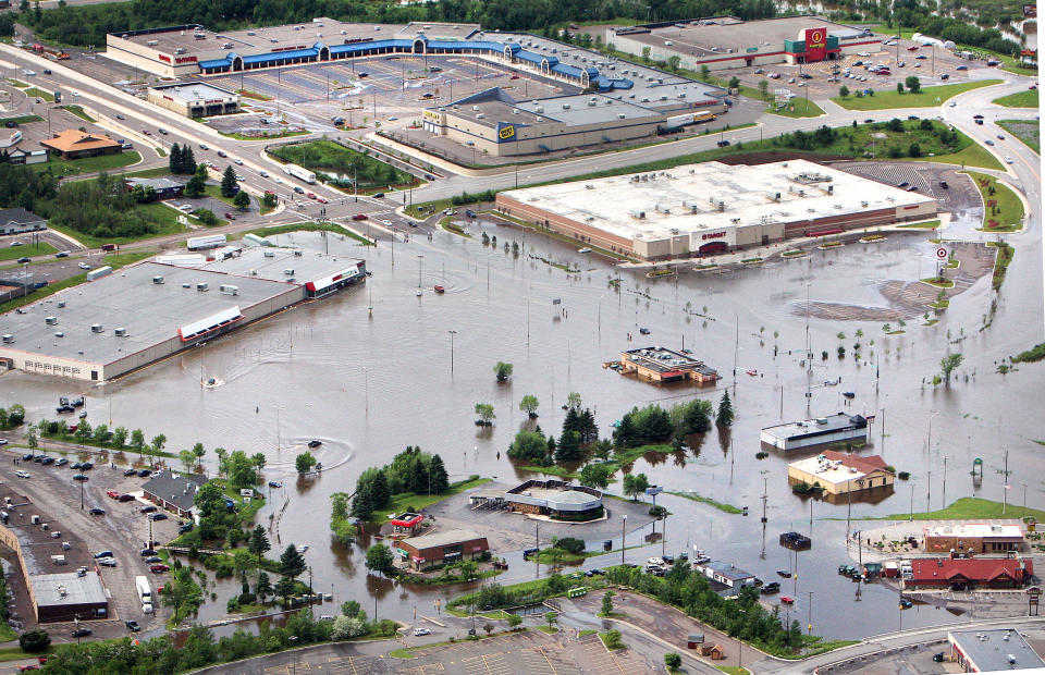 In this aerial photo, floodwaters surround the Burning Tree Plaza shopping area in Duluth, Minn., Wednesday afternoon, June 20, 2012. Residents evacuated their homes and animals escaped from pens at a zoo as floods fed by a steady torrential downpour struck northeastern Minnesota, inundating the city of Duluth, officials said Wednesday. (AP Photo/The Duluth News-Tribune, Bob King)