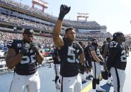 <p>Oakland Raiders outside linebacker Malcolm Smith (53) raises a fist during the playing of the national anthem before an NFL football game against the Tennessee Titans Sunday, Sept. 25, 2016, in Nashville, Tenn. At left is defensive end Khalil Mack (52) and at right is free safety Reggie Nelson (27). (AP Photo/Mark Zaleski) </p>