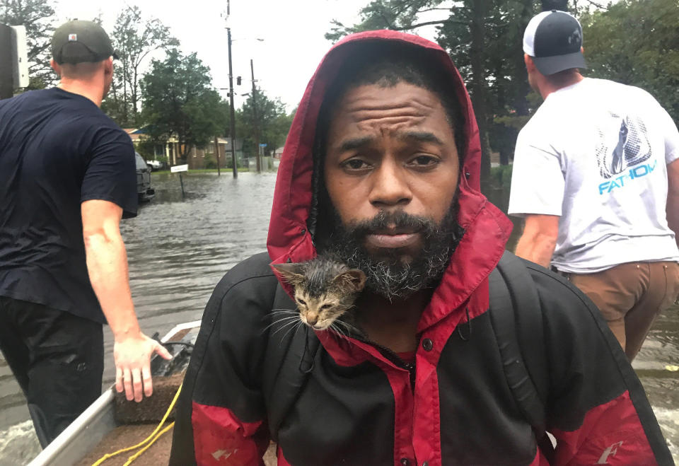 Survivor the kitten huddles inside Robert Simmons Jr.'s jacket as the pair flee rising waters in New Bern, North Carolina in the wake of Hurricane Florence. (Photo: Raleigh News & Observer via Getty Images)