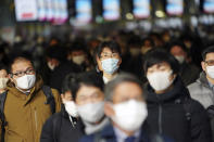 FILE - In this Jan. 4, 2021, file photo, people commute on the first business day of the year at a train station in Tokyo. Opposition to the Tokyo Olympics is growing with calls for a cancellation as virus cases rise in Japan. The International Olympic Committee and local organizers have already said another postponement is impossible, leaving cancellation, or going ahead, as the only options. (AP Photo/Eugene Hoshiko, File)