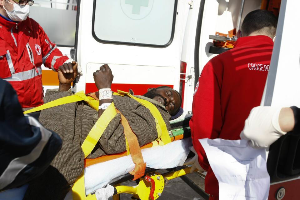 A migrant is helped by Red Cross assistants as he arrives at the Sicilian harbour of Pozzallo