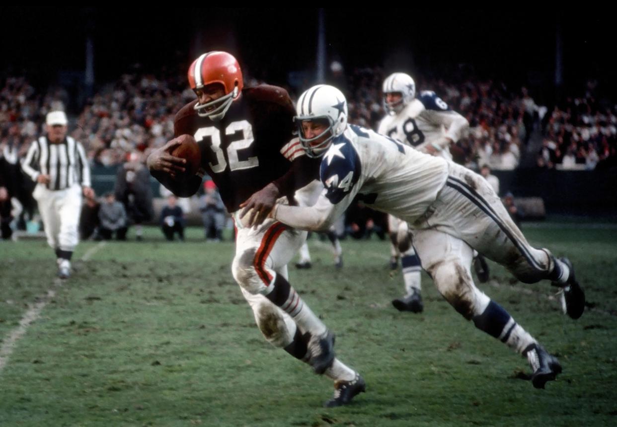 Browns running back Jim Brown tries to pull away from Dallas Cowboys defensive tackle Bob Lilly at Cleveland Stadium in an undated photo.