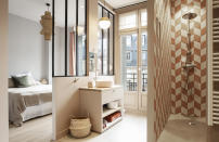 <p>Cette chambre parisienne possède sa propre salle de bains. Afin de ne pas perdre en mètres carrés, une douche à l’italienne a été aménagée. Puisqu’elle se trouve à côté de larges fenêtres, le professionnel l’a séparée du reste de la pièce par un mur et non une paroi en verre. Intimité maintenue. Le carrelage aux nuances nude et les plafonniers dédiés à ce coin l’éclaircissent.</p><p>Architecte d’intérieur : <a href="https://www.houzz.fr/pro/tatioushka/tatiana-nicol" rel="nofollow noopener" target="_blank" data-ylk="slk:Tatiana Nicol" class="link ">Tatiana Nicol</a></p><br>