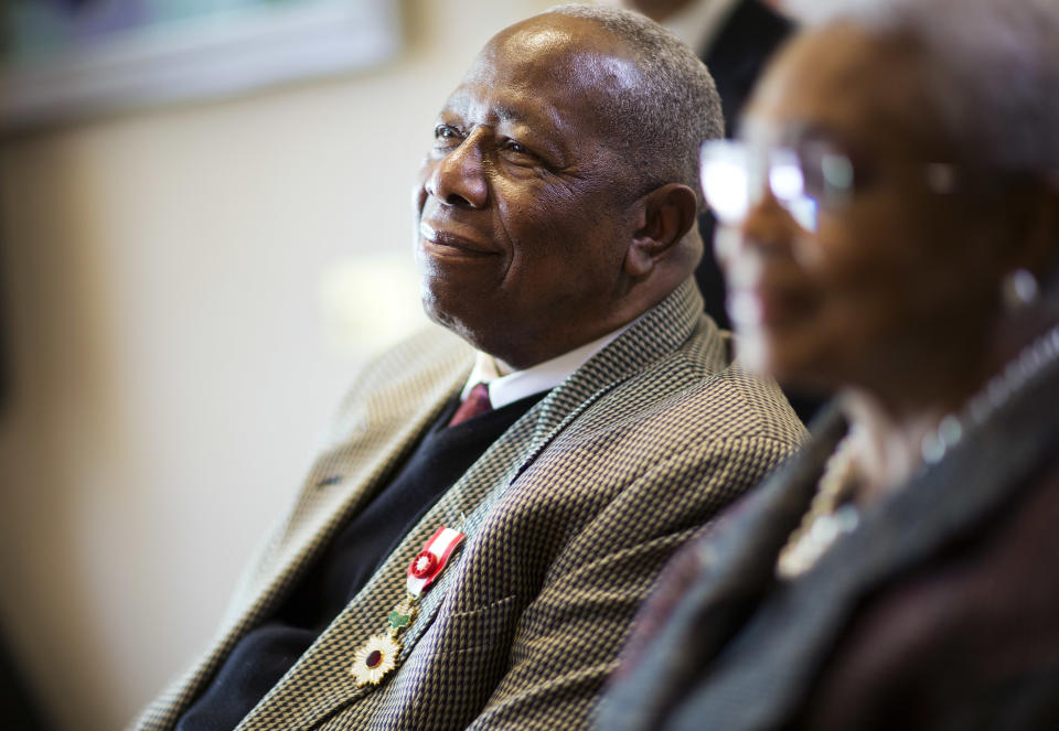 FILE- In this Jan. 14, 2016, file photo, Hank Aaron, left, looks on with wife Billye during a ceremony presenting him the Order of the Rising Sun, Gold Rays with Rosette, by the Consul General of Japan at his official residence in Atlanta. Hank Aaron, who endured racist threats with stoic dignity during his pursuit of Babe Ruth but went on to break the career home run record in the pre-steroids era, died early Friday, Jan. 22, 2021. He was 86. The Atlanta Braves said Aaron died peacefully in his sleep. No cause of death was given. (AP Photo/David Goldman, File)