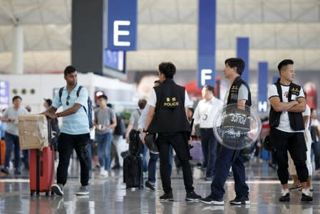 Police patrol the departure hall of the airport in Hong Kong after previous night's clashes with protesters