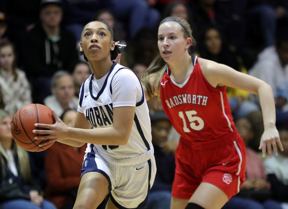 Hoban's Mackenzie Edingburgh, left, drives to the basket ahead of Wadsworth's Brooke Baughman during the first half of a high school basketball game, Wednesday, Feb. 14, 2024, in Akron, Ohio.