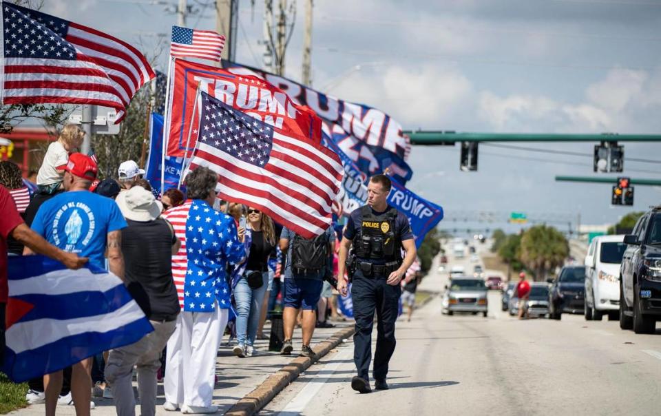 Un policía controla a una multitud de seguidores del ex presidente Donald Trump durante un mitin, el lunes 3 de abril de 2023, en West Palm Beach, Florida. Los partidarios se reunieron para ver la caravana de Trump mientras se dirigía al Aeropuerto Internacional de Palm Beach.