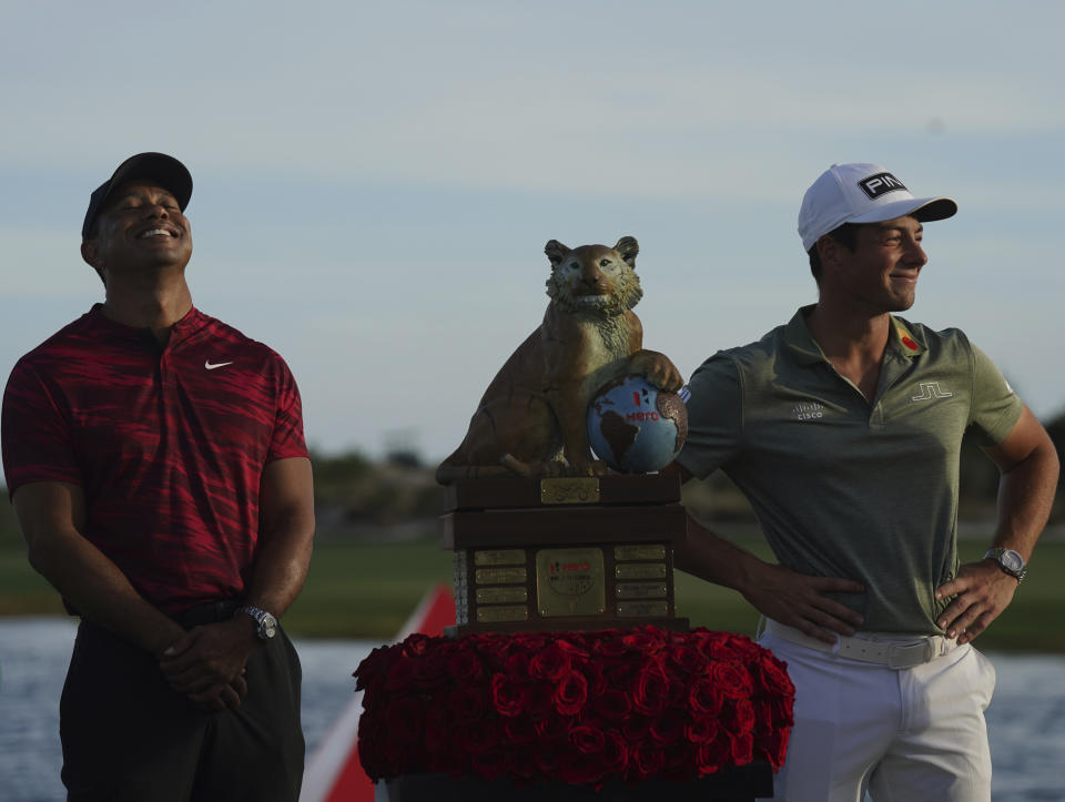 Viktor Hovland, of Norway, right, and Tiger Woods pose for the photographers during the trophy ceremony of the Hero World Challenge PGA Tour at the Albany Golf Club, in New Providence, Bahamas, Sunday, Dec. 5, 2021. Viktor Hovland won the tournament with -17 strokes under par.. (AP Photo/Fernando Llano)