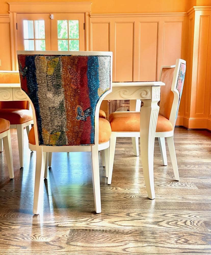 For a Washington, D.C., dining room, McLeod covered chairs in warm Ultrasuede Orange accented by a multicolored Hunt Slonem print