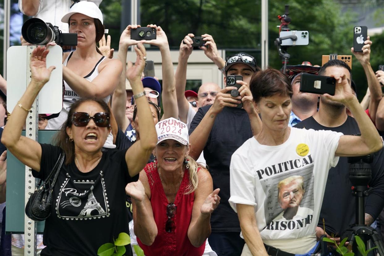 Supporters, including one wearing a t-shirt bearing former President Donald Trump's photo that says "Political prisoner," watch as Trump departs the federal courthouse after arraignment, June 13, 2023, in Miami. <a href="https://newsroom.ap.org/detail/APTOPIXTrumpClassifiedDocuments/6b13a7ec06c746b8ac6362222e5bf49a/photo?Query=Trump%20supporters&mediaType=photo&sortBy=arrivaldatetime:desc&dateRange=Anytime&totalCount=13151&currentItemNo=24" rel="nofollow noopener" target="_blank" data-ylk="slk:AP Photo/Gerald Herbert;elm:context_link;itc:0;sec:content-canvas" class="link ">AP Photo/Gerald Herbert</a>