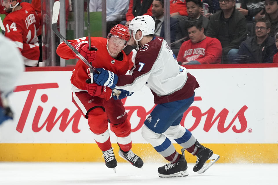 Detroit Red Wings left wing Lucas Raymond (23) is checked by Colorado Avalanche defenseman Devon Toews (7) in the second period of an NHL hockey game Thursday, Feb. 22, 2024, in Detroit. (AP Photo/Paul Sancya)