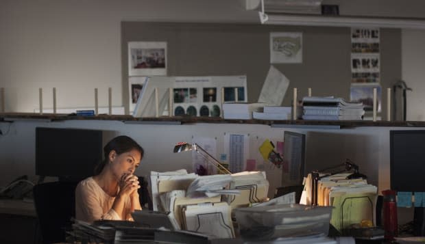 Mixed race businesswoman working late in office